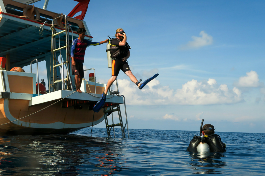 Plunging into the ocean in full scuba diving gear near Koh Tao