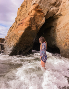 Standing in the surf near a sea cave